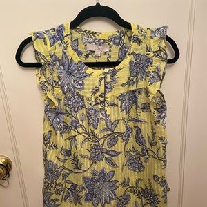 Bright yellow blouse with navy florals. Ruffles at sleeves